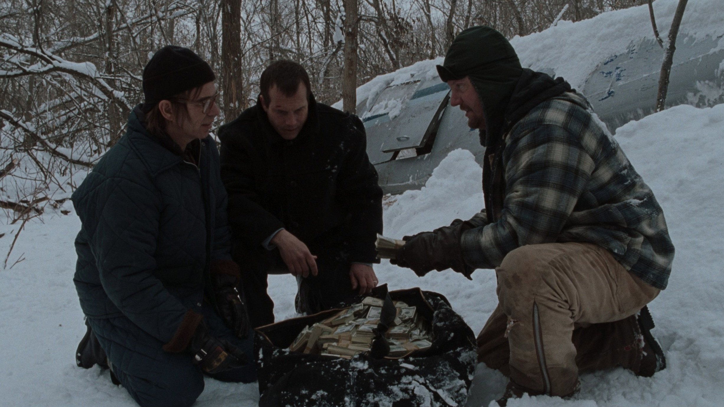 The characters of A Simple Plan beside the bag of money found in the snow