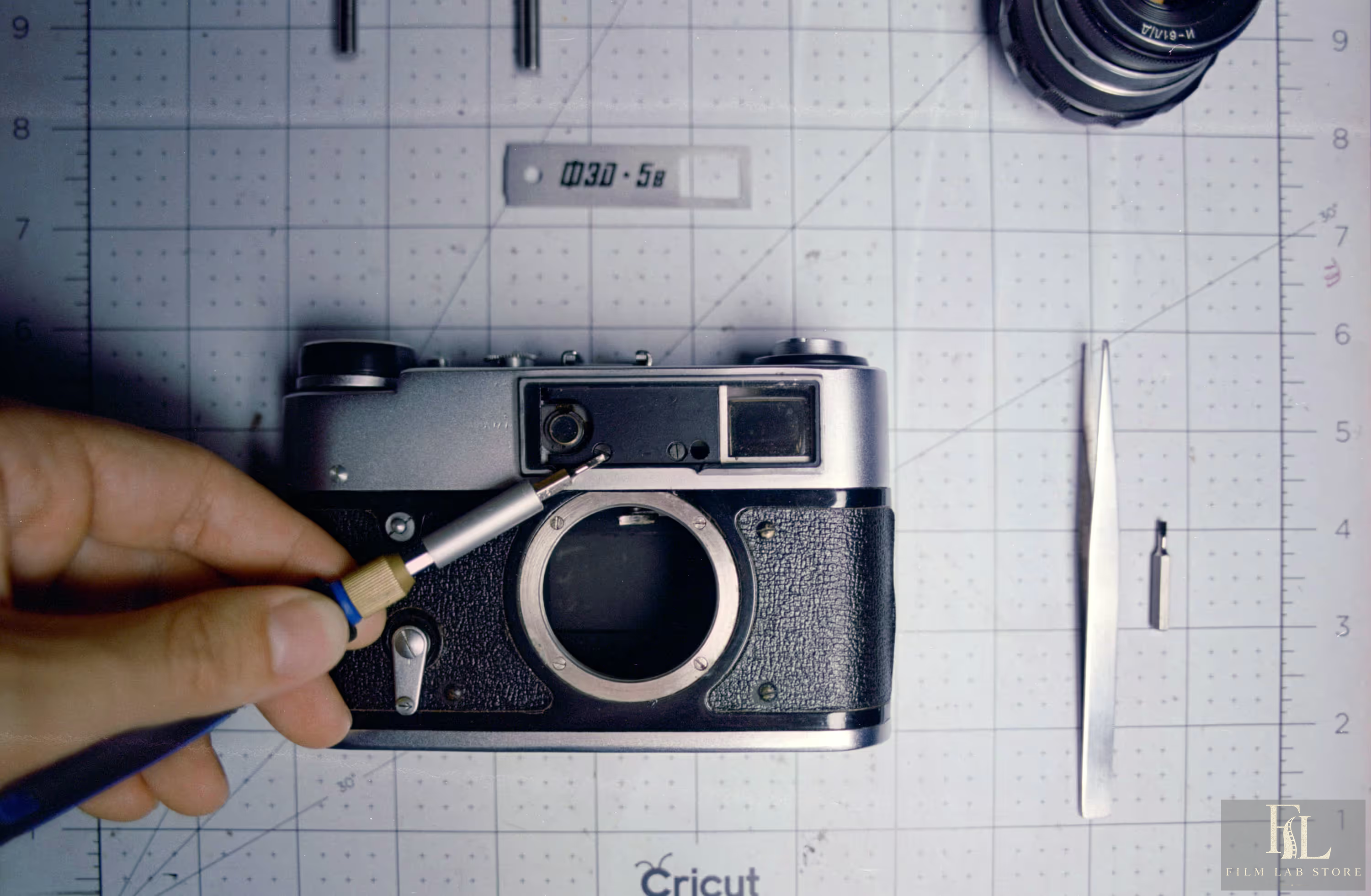 Rangefinder camera being adjusted with a screwdriver