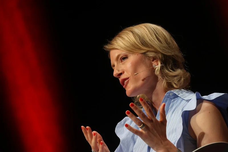 a woman is speaking into a microphone on a stage .