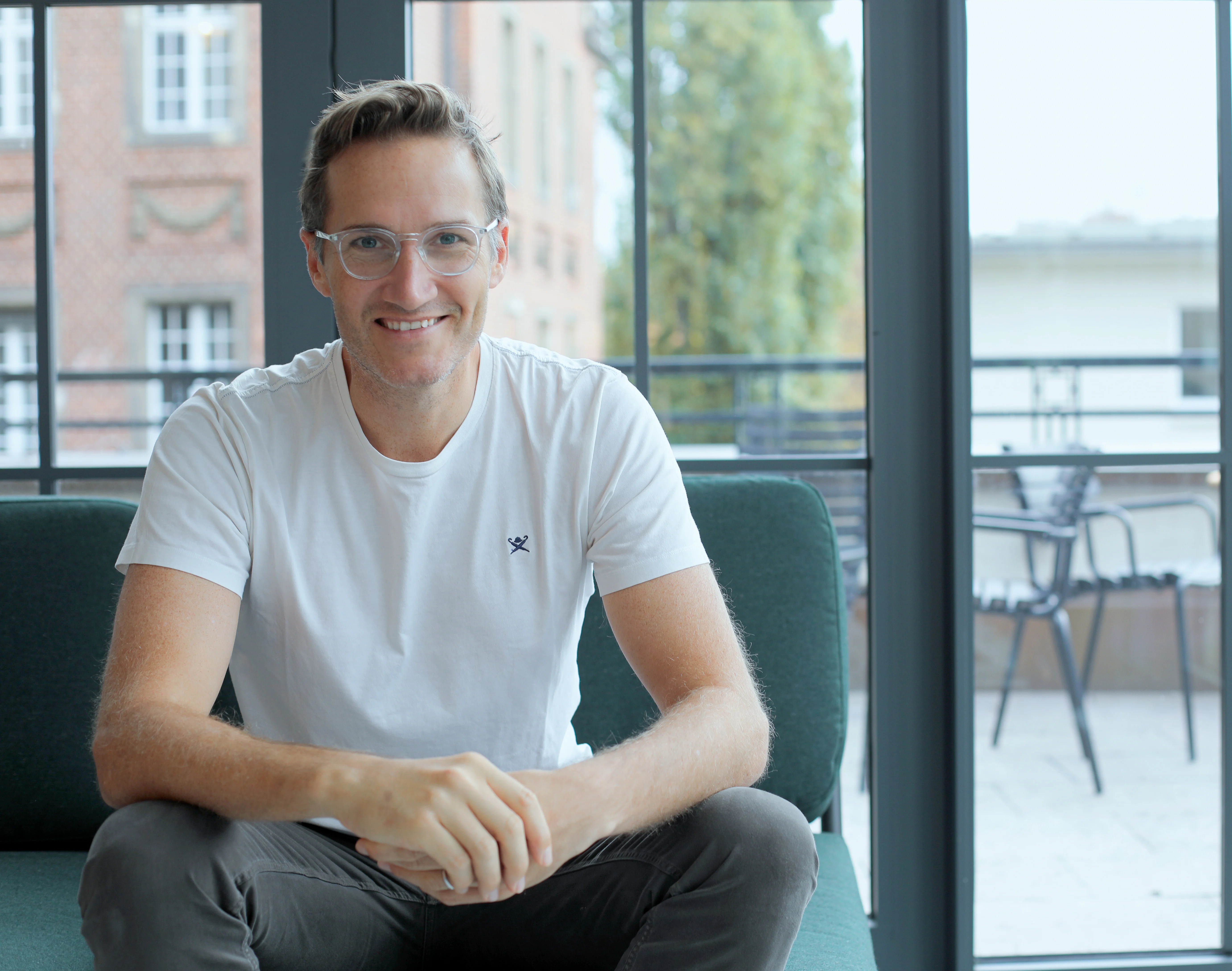 a group of people are standing next to each other on a red carpet cutting a red ribbon.