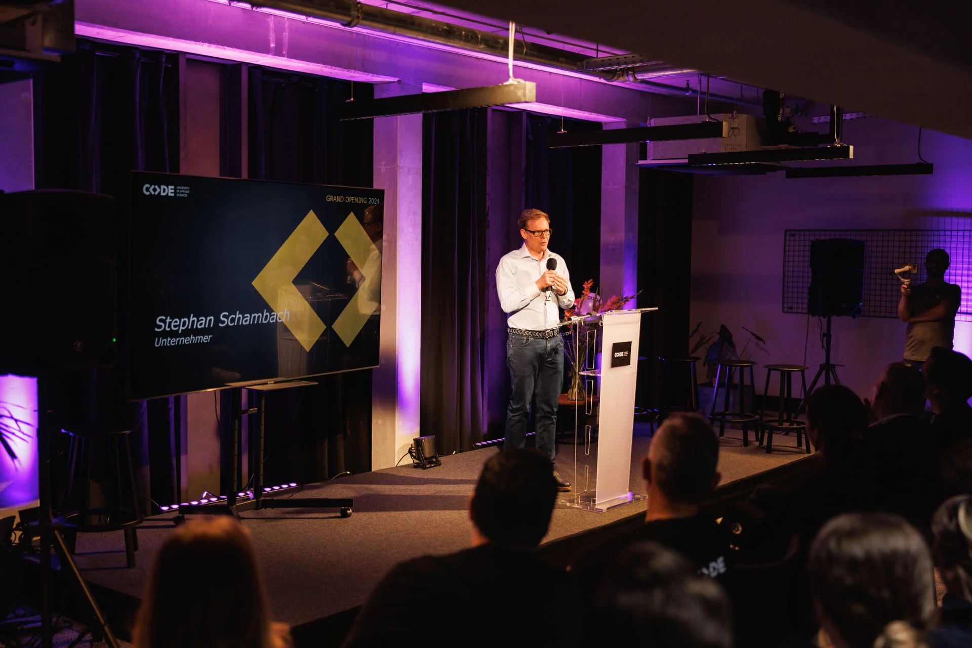 a group of people are standing next to each other on a red carpet cutting a red ribbon.