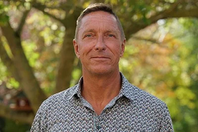 a group of people are standing next to each other on a red carpet cutting a red ribbon.
