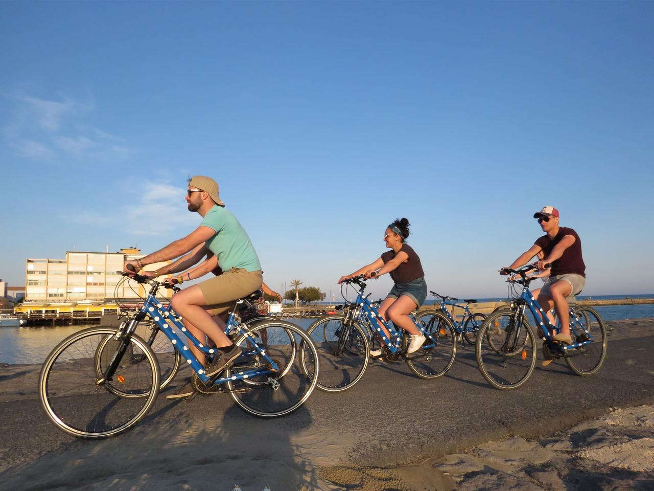Trois cyclistes au bord de l’eau sous un ciel bleu