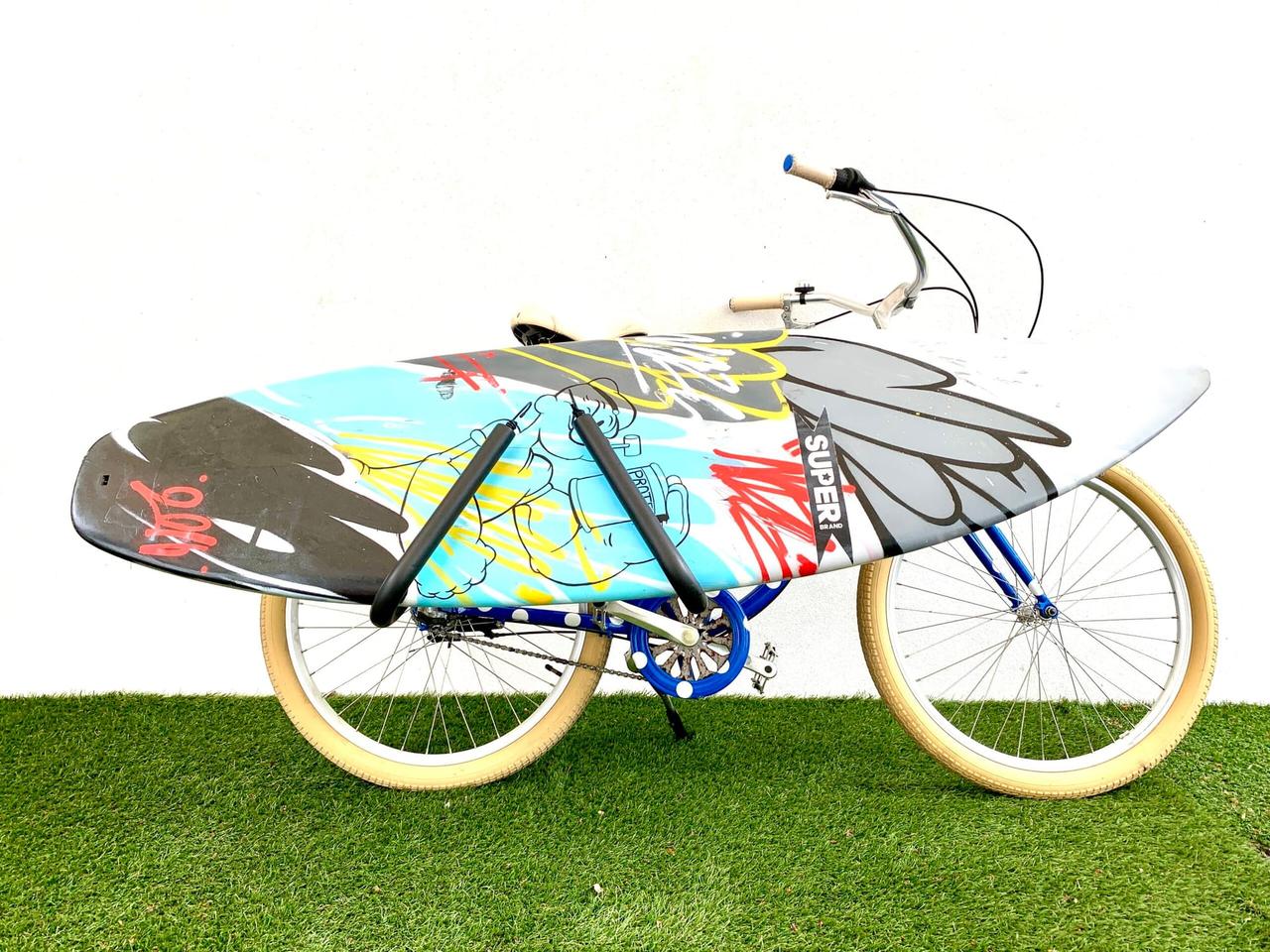 Vélo équipé d’un porte-surf avec une planche