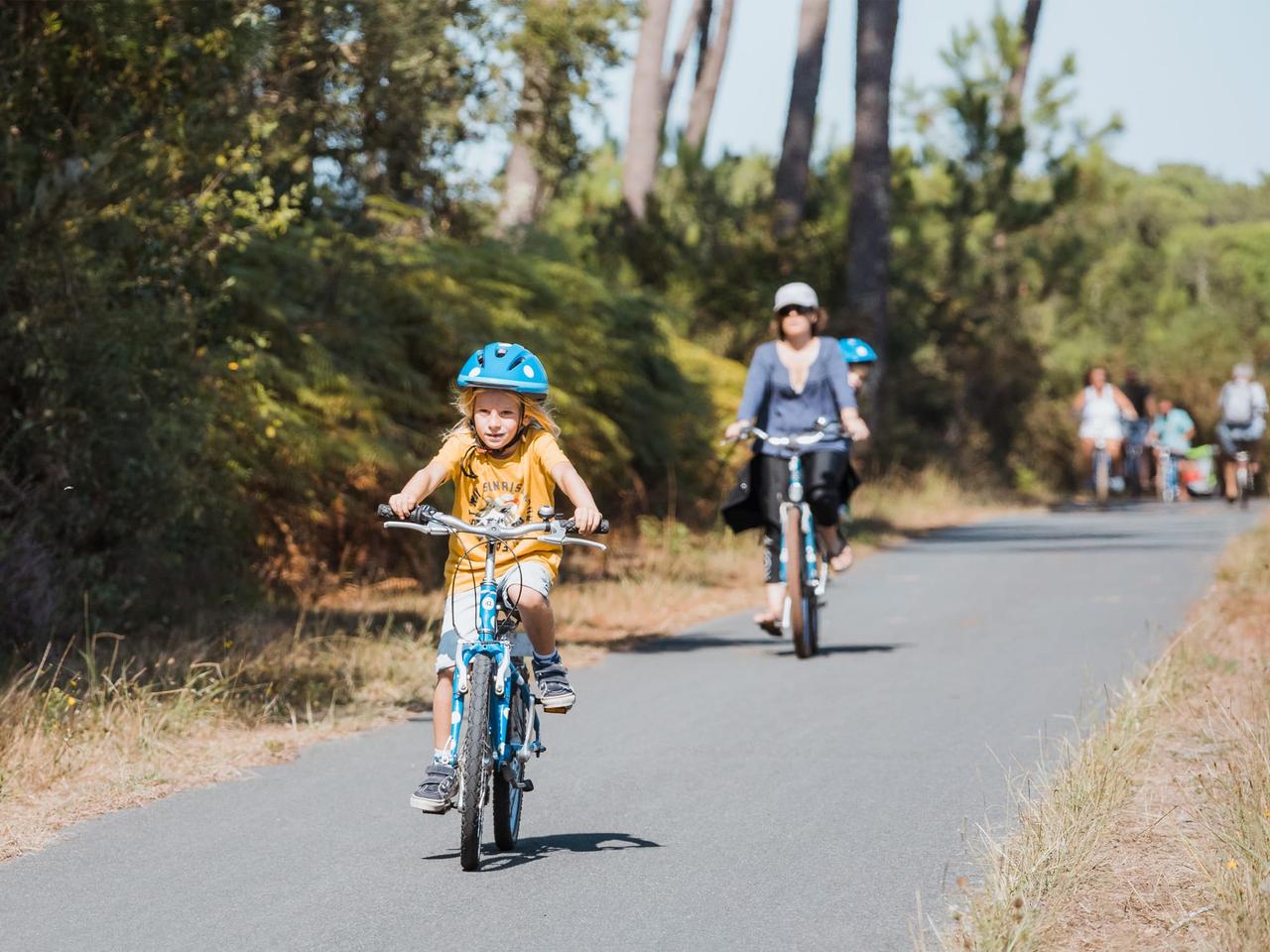 Enfant à vélo sur une piste cyclable en forêt