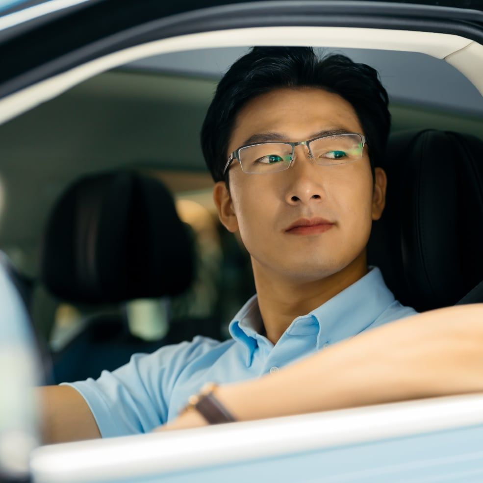 Man with glasses sitting in car after purchasing vehicle through Drivvn automotive eCommerce platform