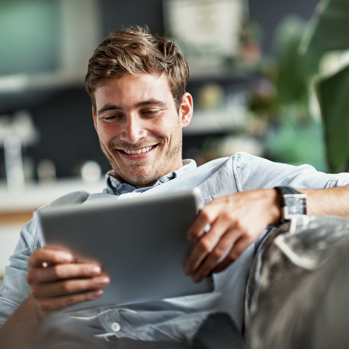 Smiling young professional browsing cars on Drivvn-powered automotive eCommerce storefront using tablet device