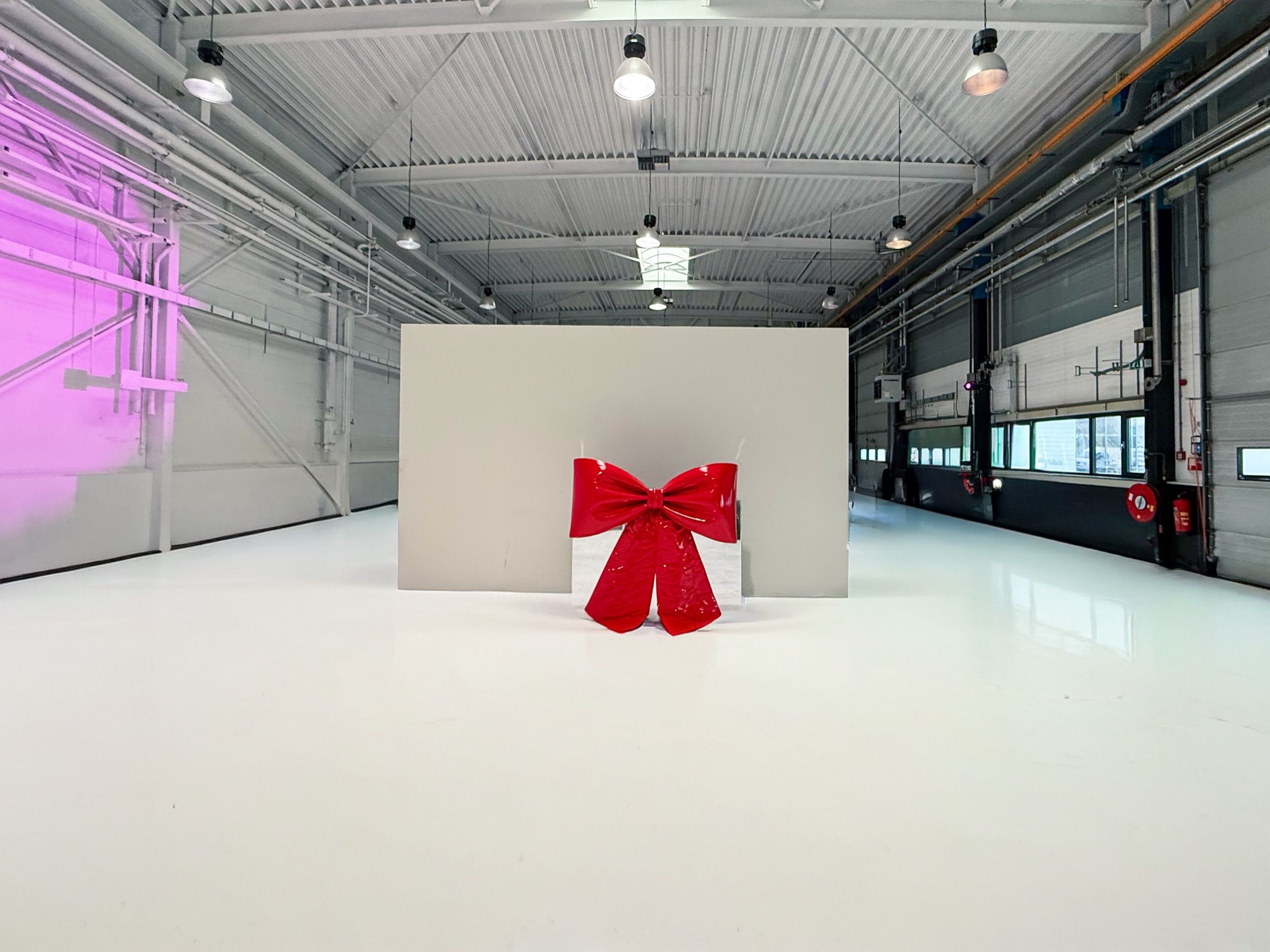 The red bow in front of a white wall in the hall, seen from a distance
