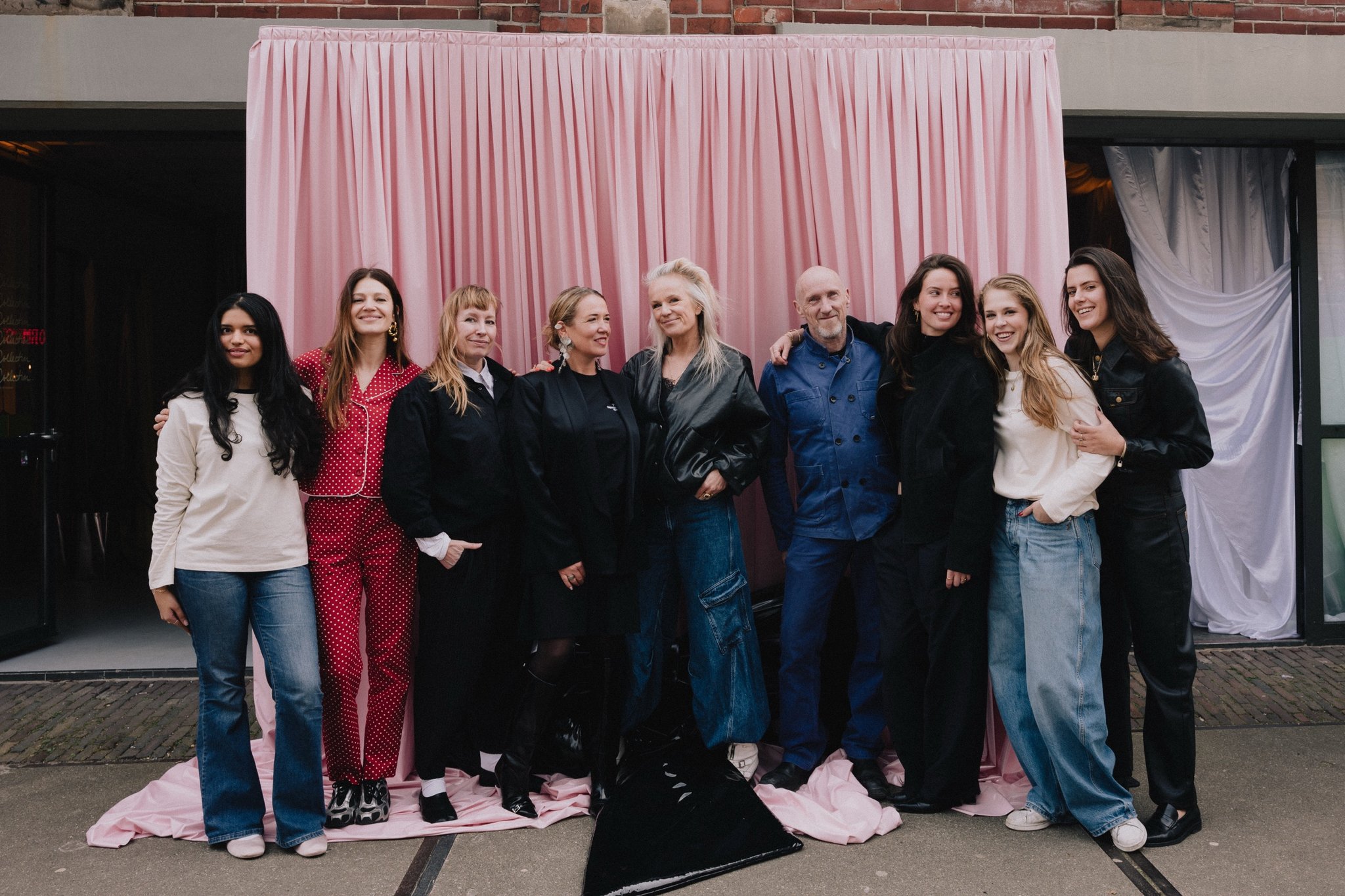 The City Dressers team in front of a pink drape with a black patent bow at their feet
