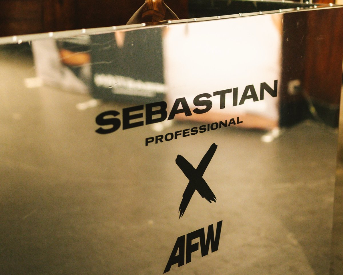 Mirror bar with the Sebastian Professional × AFW mark, glasses on a small table behind