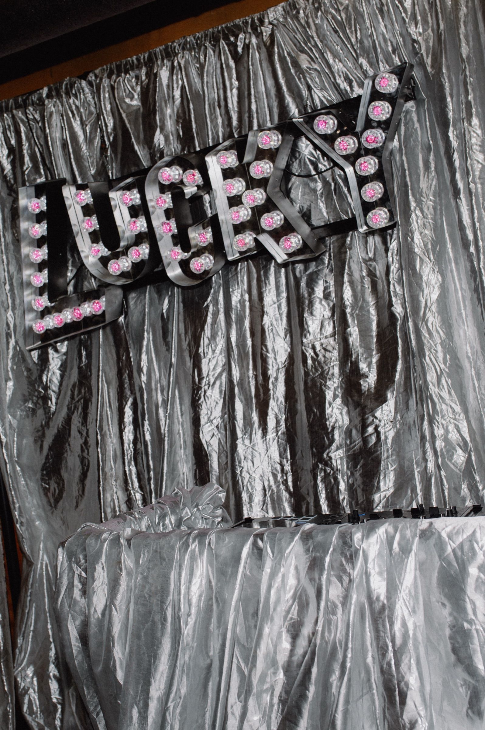 The Lucky marquee light sign on a silver drape photo wall