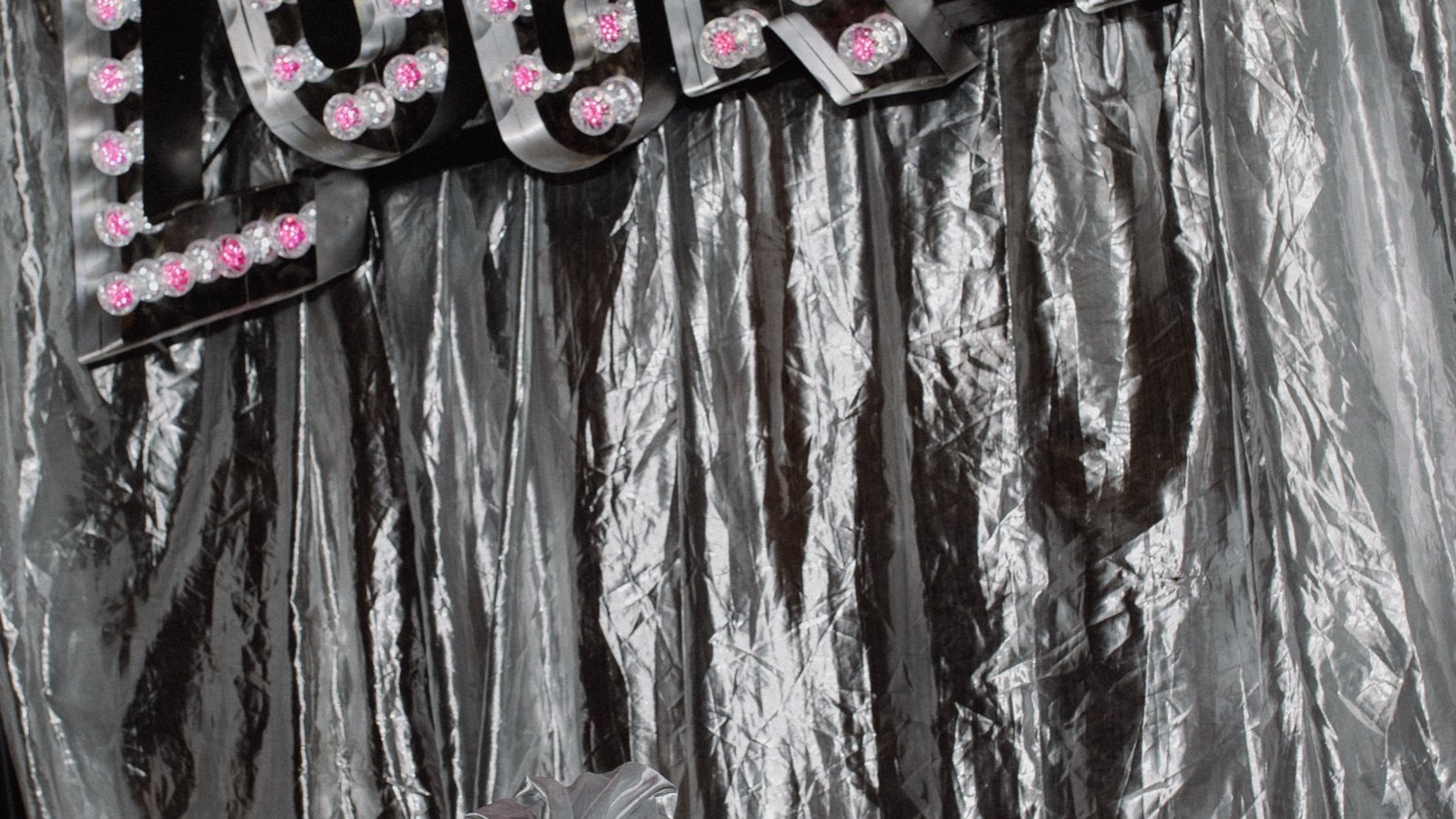 The Lucky marquee light sign on a silver drape photo wall