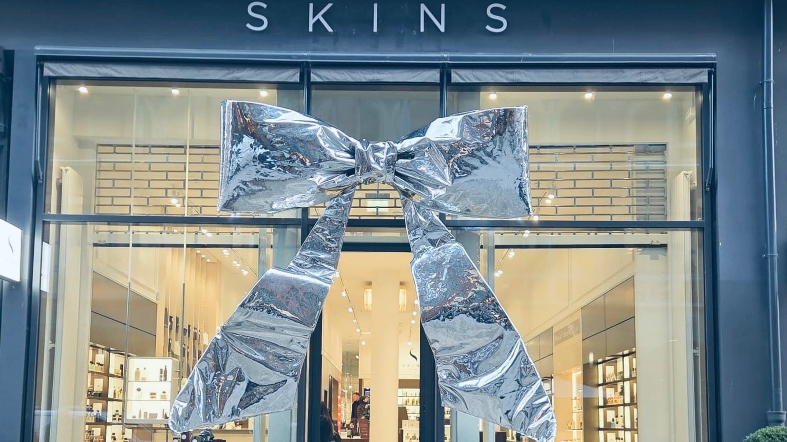 A large silver bow tied across the glass front of the Skins store