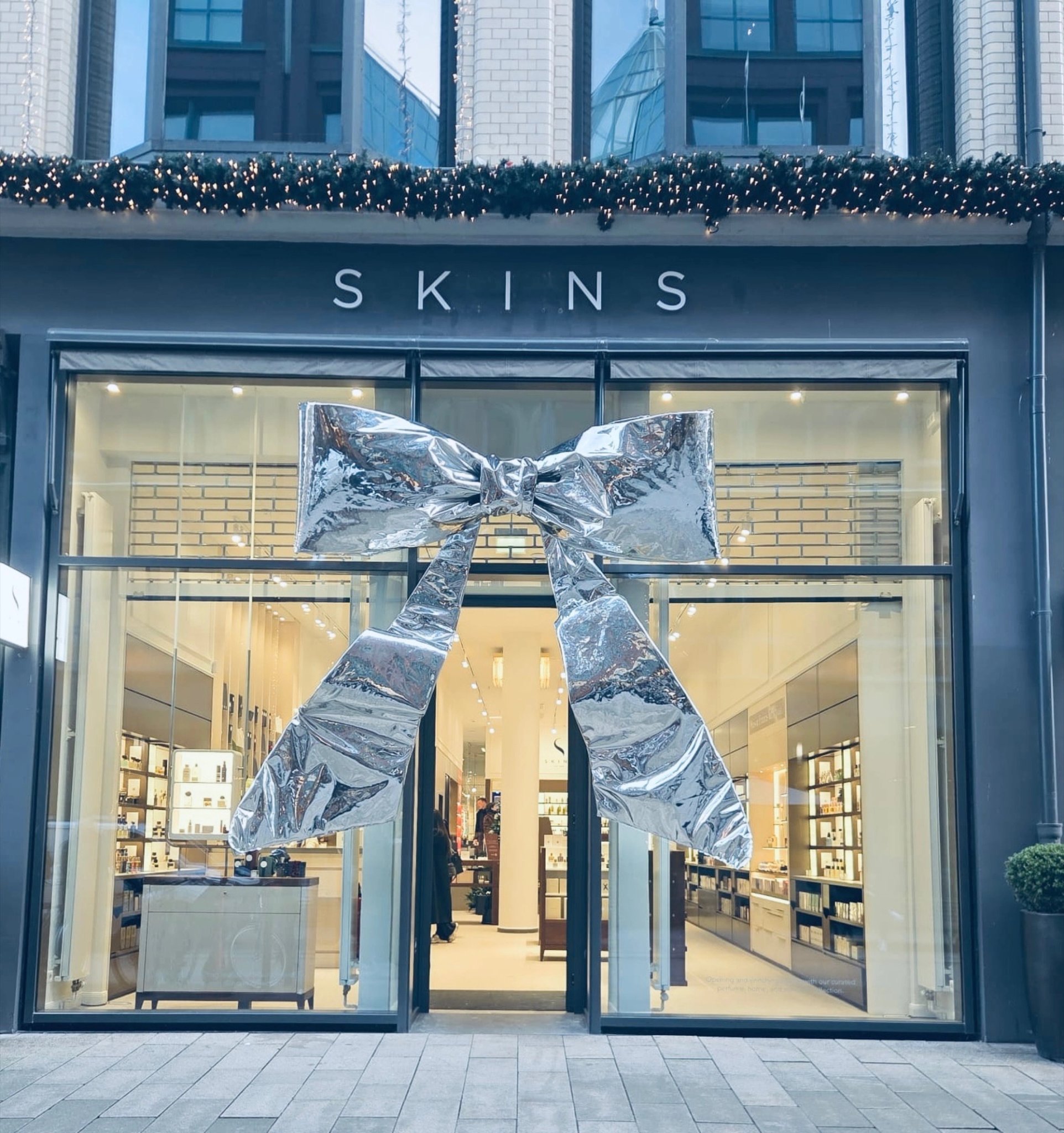 A large silver bow tied across the glass front of the Skins store