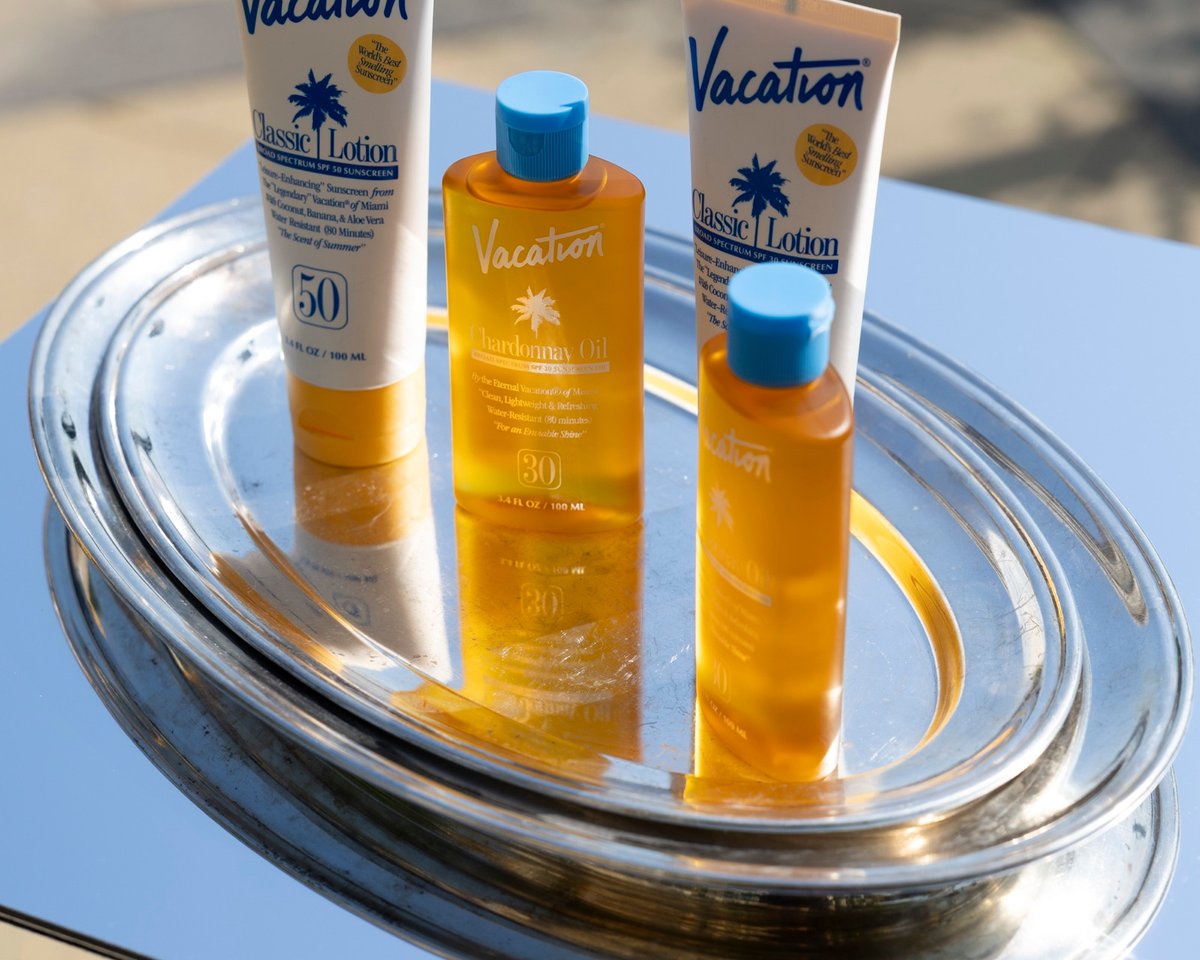 Sunscreen bottles on a silver tray on a mirror trolley, in the sun