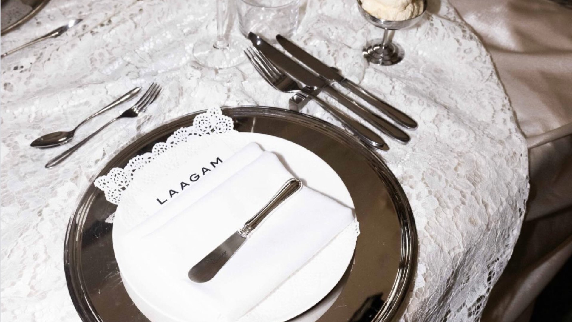 Mirror charger plates and glassware on a lace tablecloth for the Laagam dinner