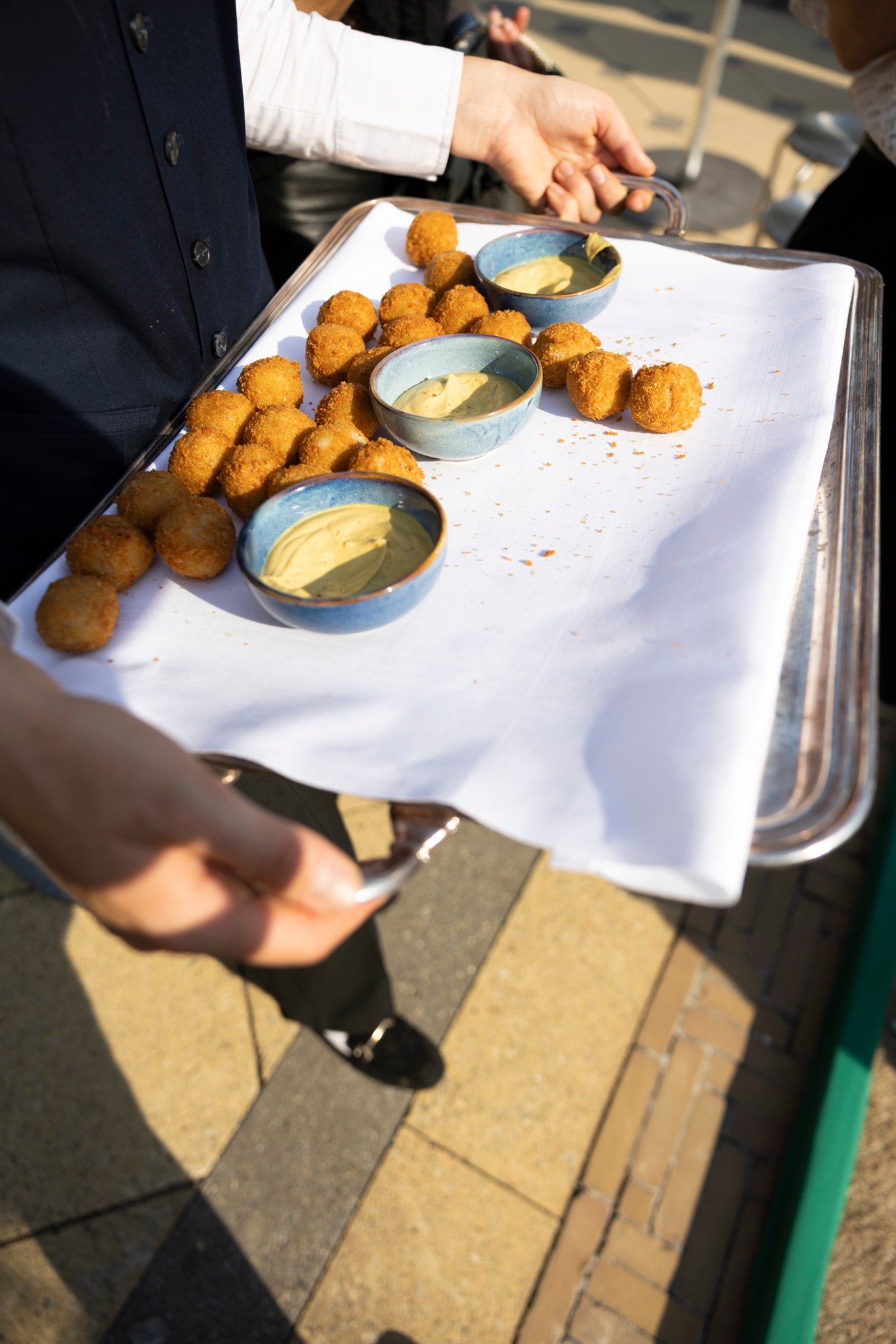 A tray of bitterballen and mustard carried through the crowd
