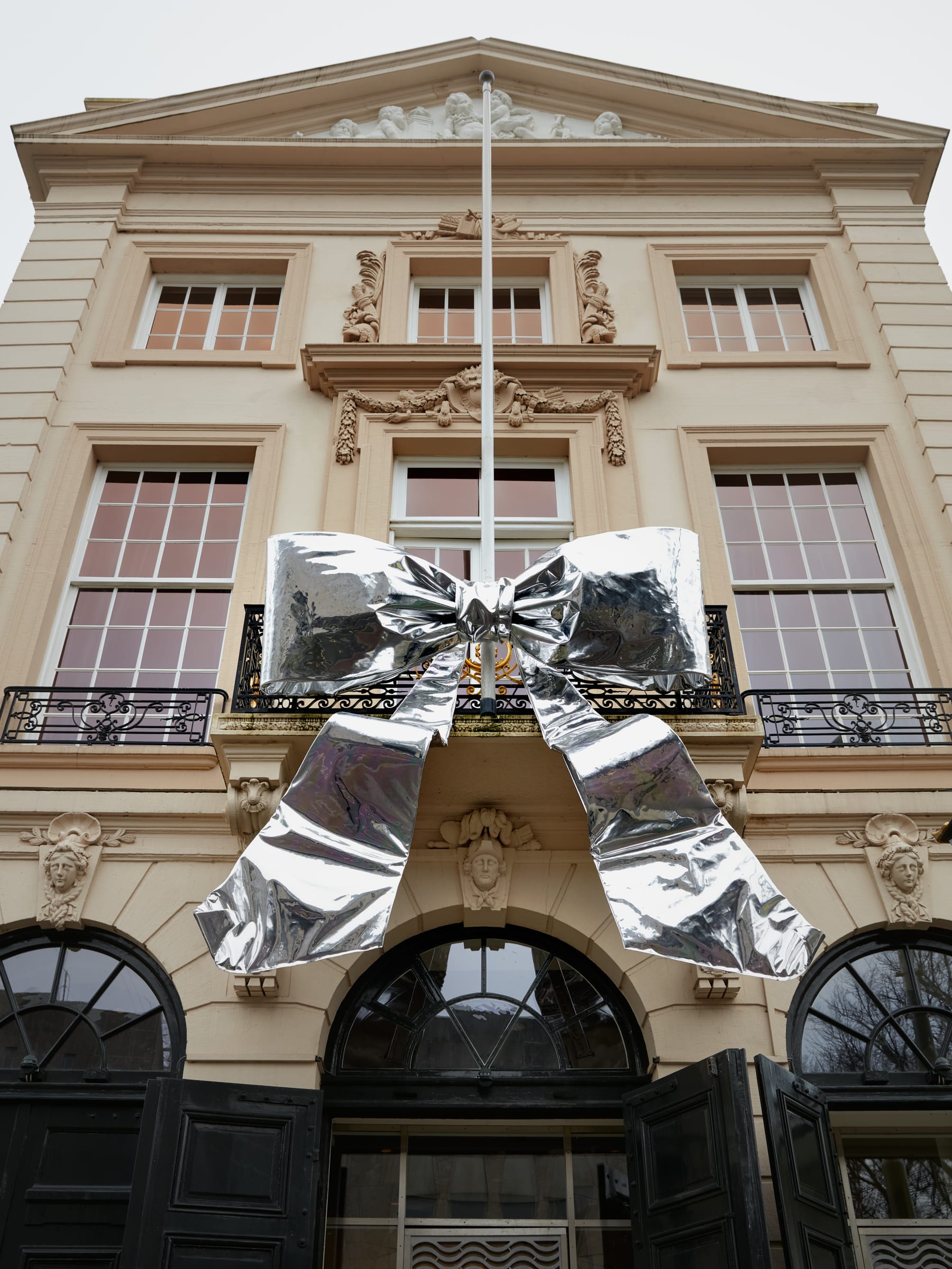 Large silver bow on the balcony of a classical facade