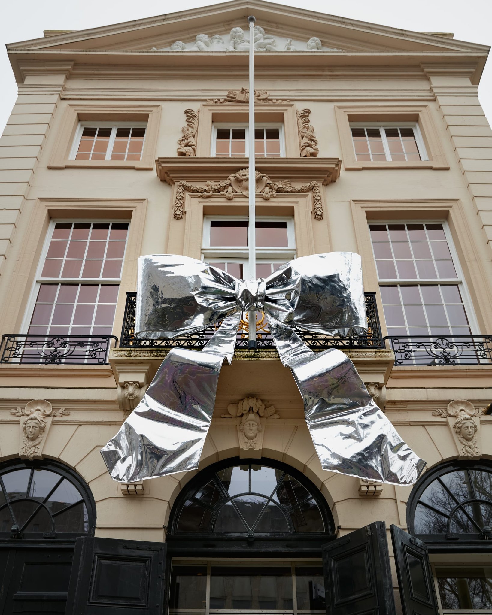 Large silver bow on the balcony of a classical facade