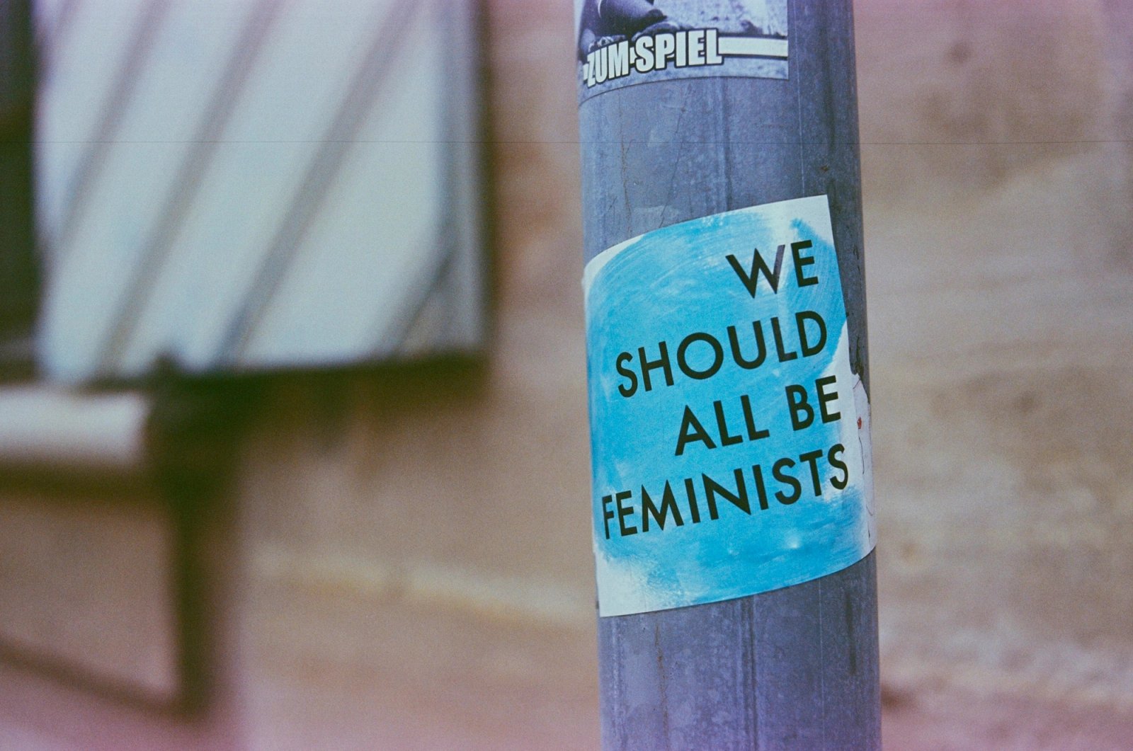 A teal sticker on a grey pole reads 