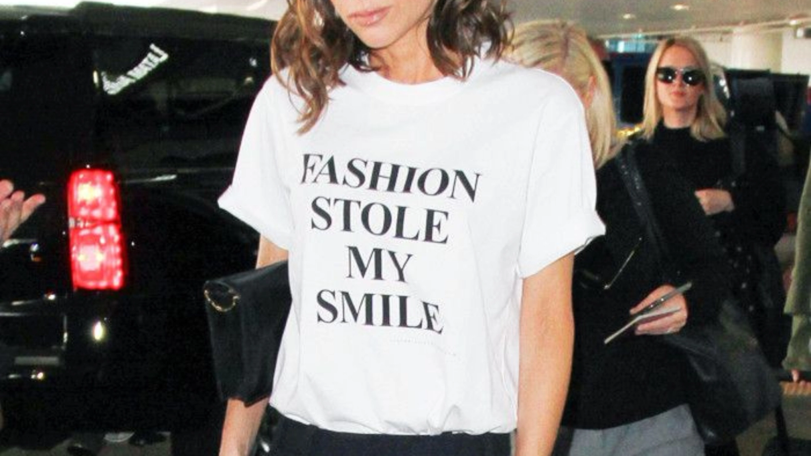 Victoria Beckham is wearing a white T-shirt that says 