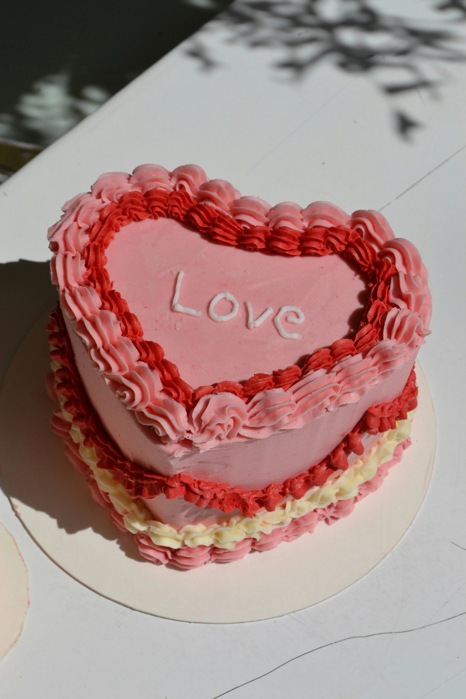 A pink heart-shaped cake with 