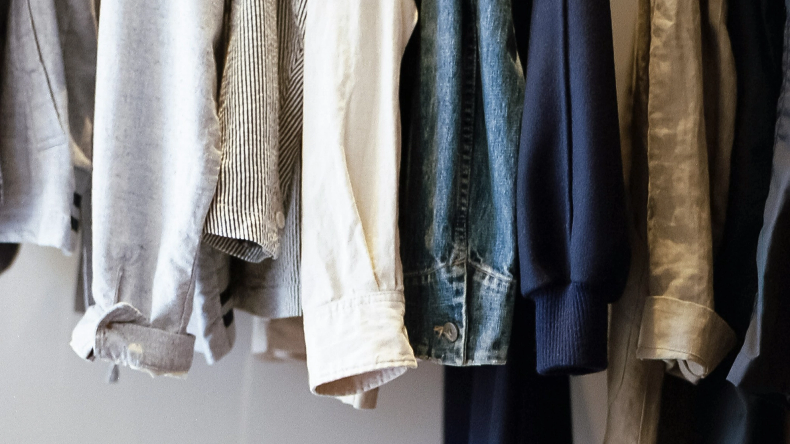 Various items of clothing hanging on a rack.