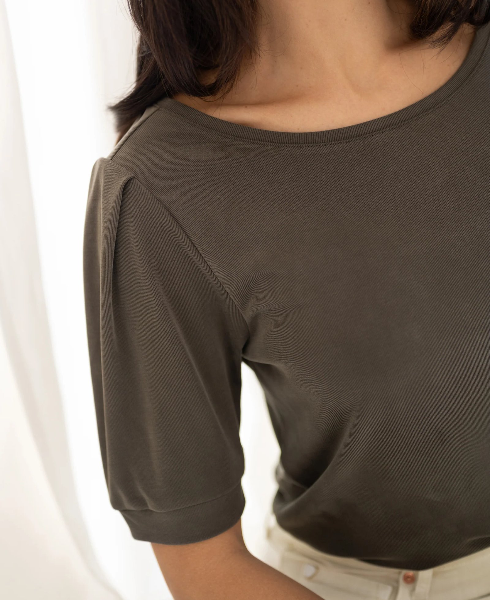 Olive green ribbed knit top with pleated puff sleeves and a boat neck.