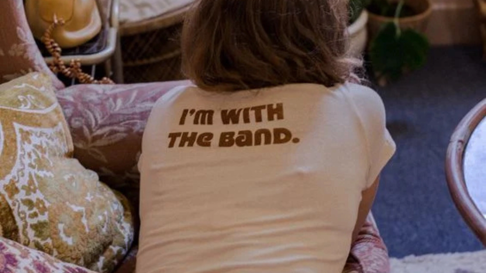 The back of a person wearing a white T-shirt with the text 