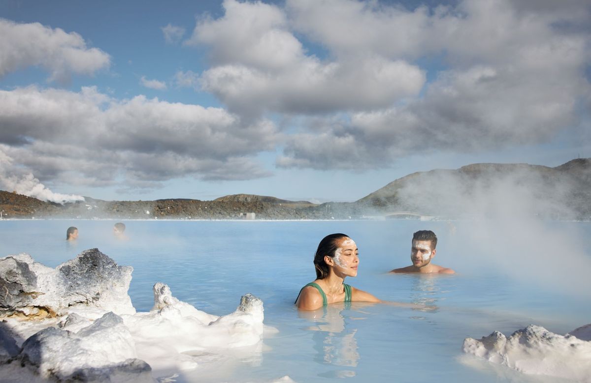 Bathers with mud masks looking at the mountains from the Blue Lagoon