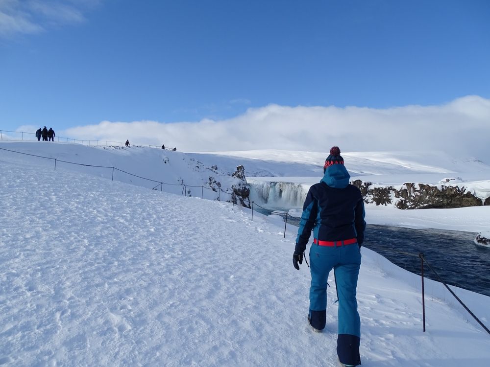 A traveler walking in the snowcapped Iceland surrounded by mountains