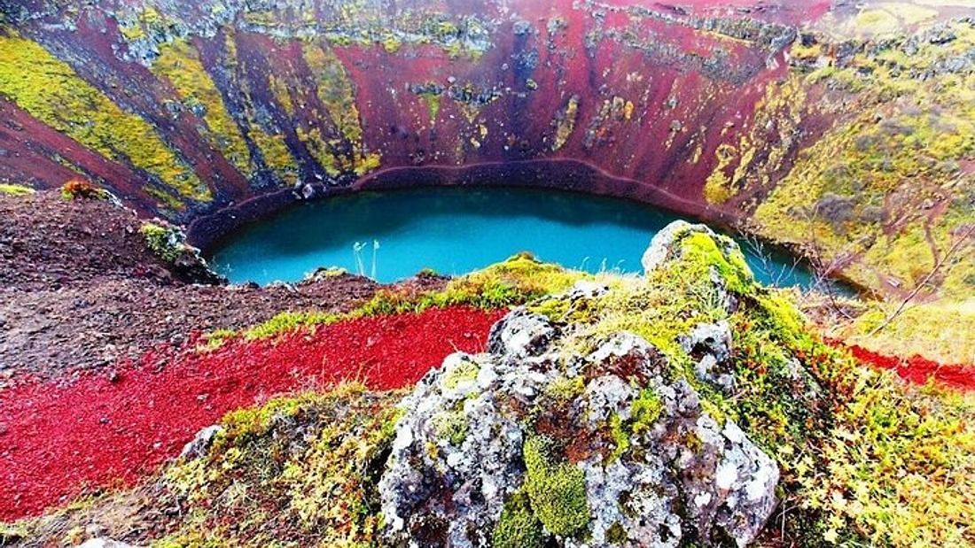 The red rim of Kerið crater above its blue-green lake