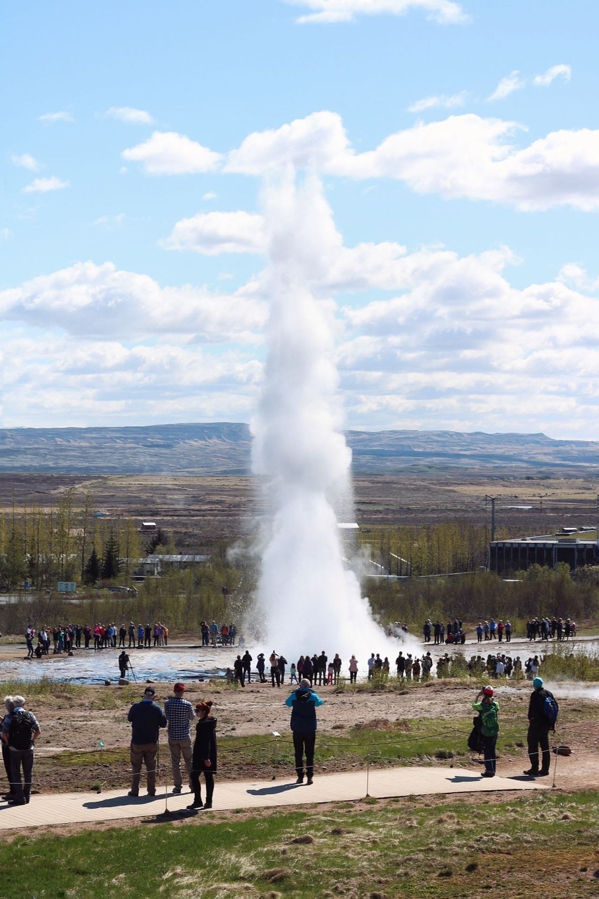 Strokkur erupting in front of a crowd