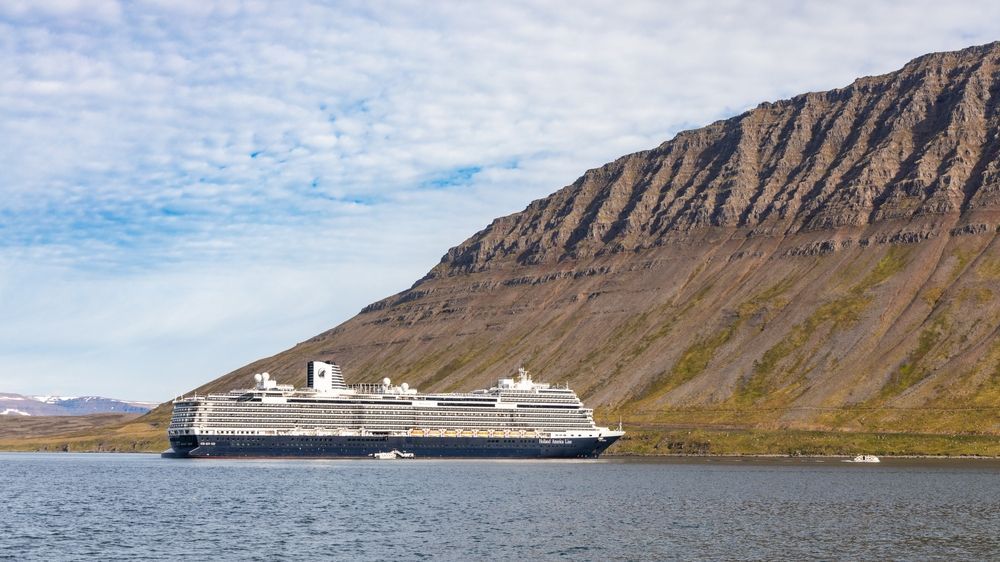 A cruise ship sailing through an Icelandic fjord