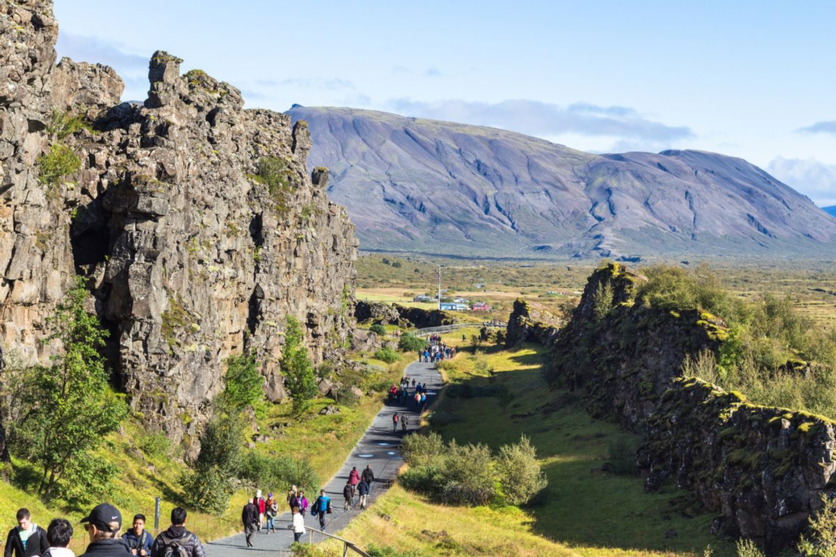 Visitors walking through Almannagjá Gorge, Thingvellir National Park, Iceland.