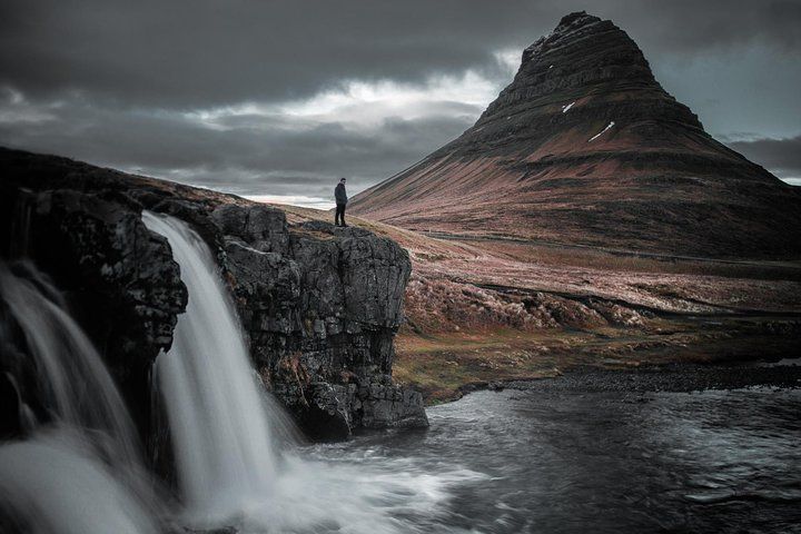 Kirkjufell mountain with the waterfall and a person in the foreground