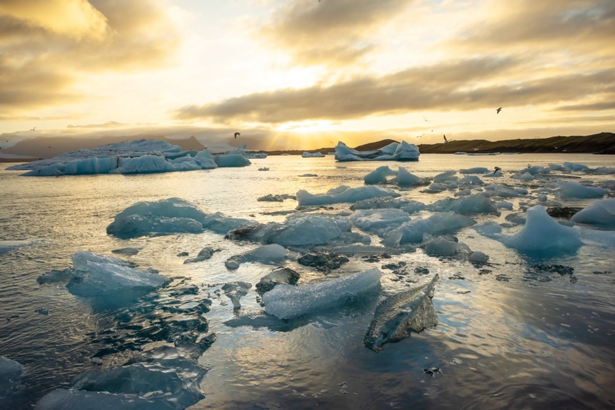 Icebergs drifting across Jökulsárlón Glacier Lagoon at sunset, Iceland.
