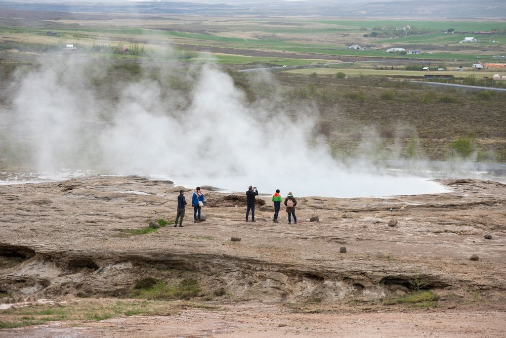 Tourists visiting and waiting for the eruption of Strokkur geyser in the Golden Circle of Iceland