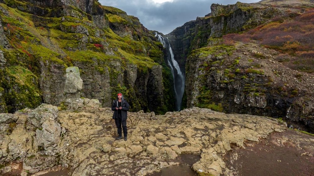 Man taking a picture with drone at Glymur Waterfall in iceland