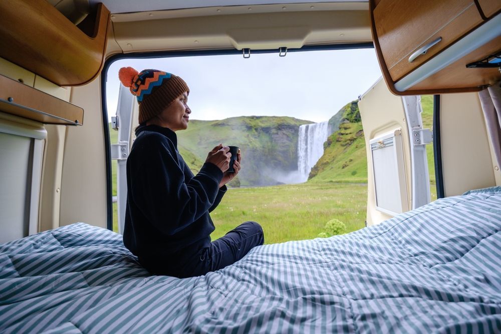 A woman in a campervan with a waterfall view