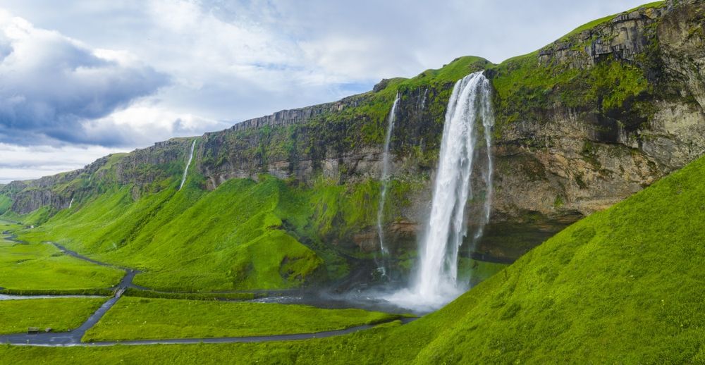 Seljalandsfoss waterfall flows from a tall cliff in Iceland