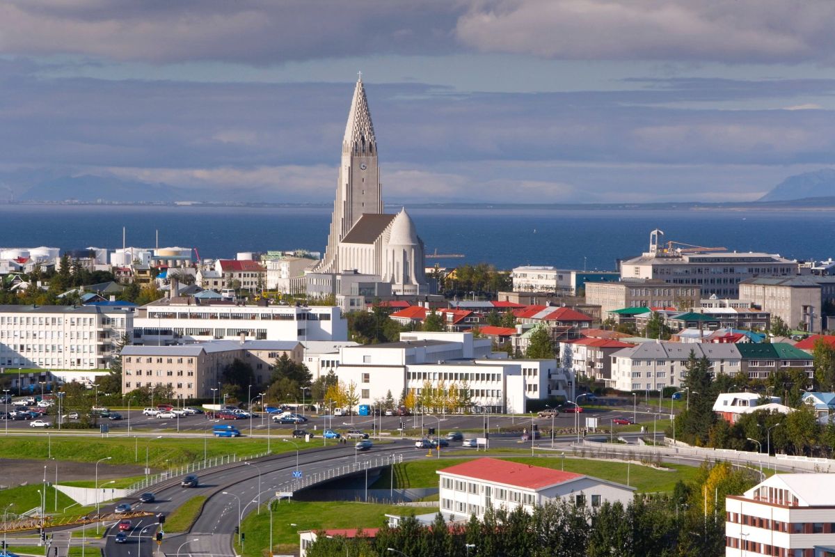 Hallgrímskirkja church rising above Reykjavík's rooftops and harbour on an overcast day