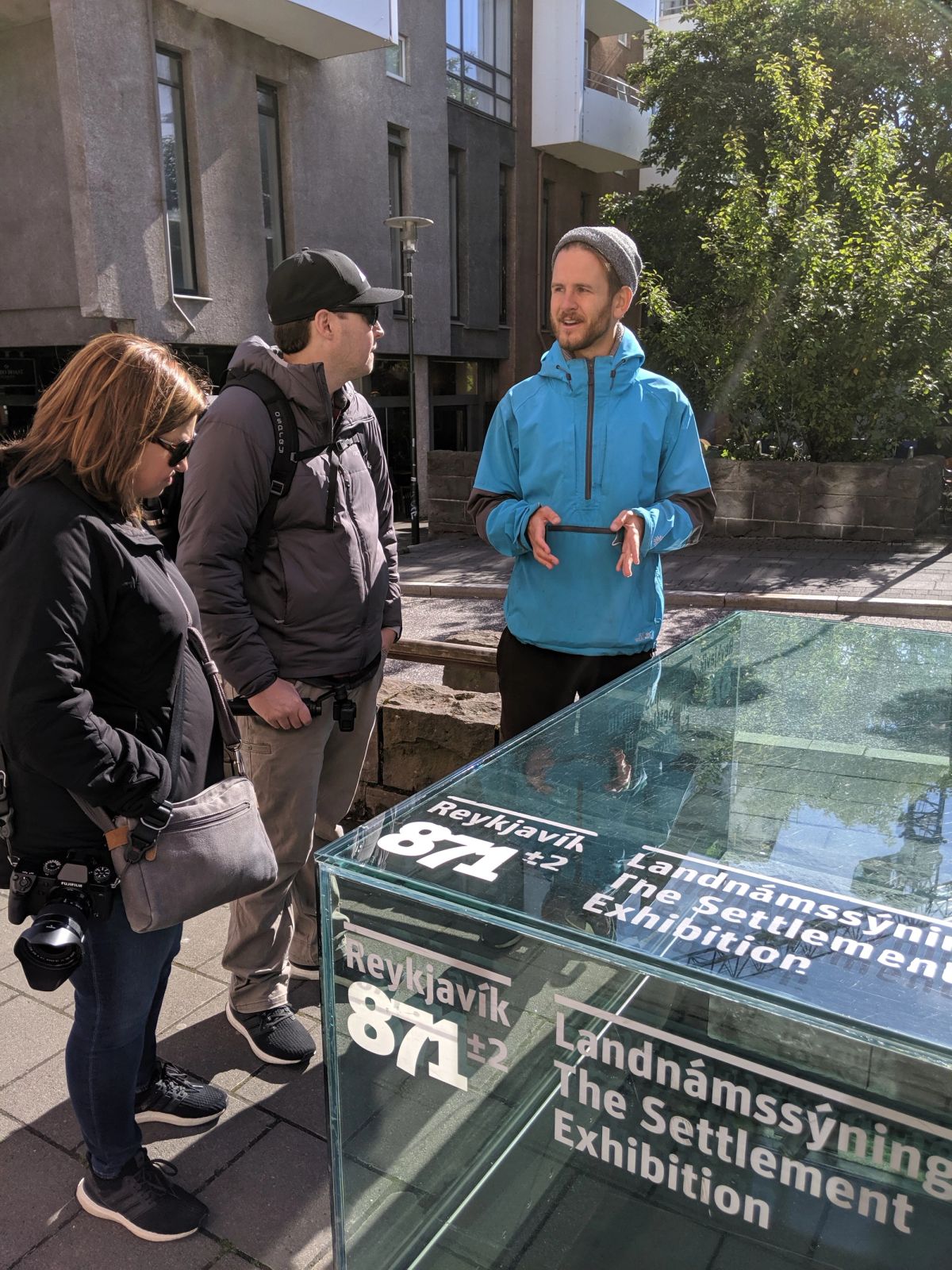 Visitors and a guide looking at the excavated Viking longhouse remains at the Settlement Exhibition in Reykjavik