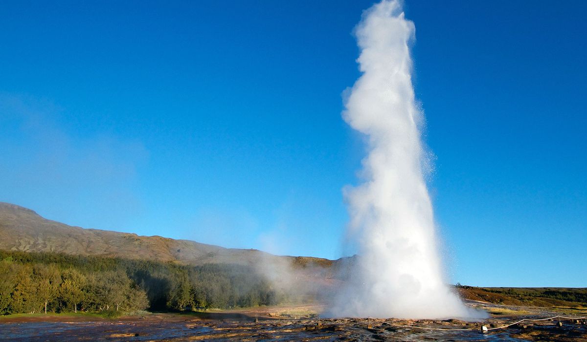 Strokkur erupting against a clear blue sky at Geysir