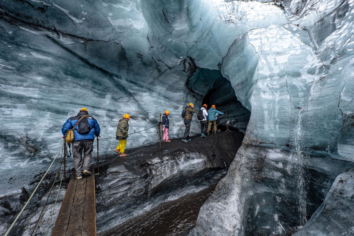 A group walking through a glacier ice cave