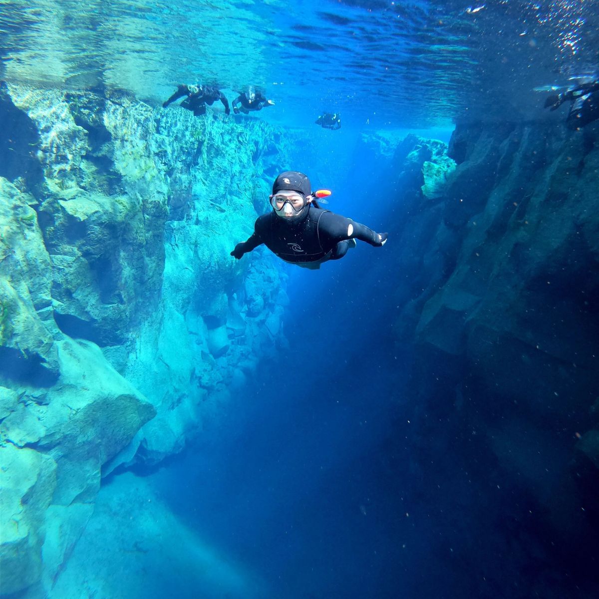 A snorkeller in the blue water of the Silfra canyon