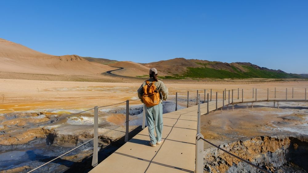 A traveler exploring the Hverir geothermal area in Iceland