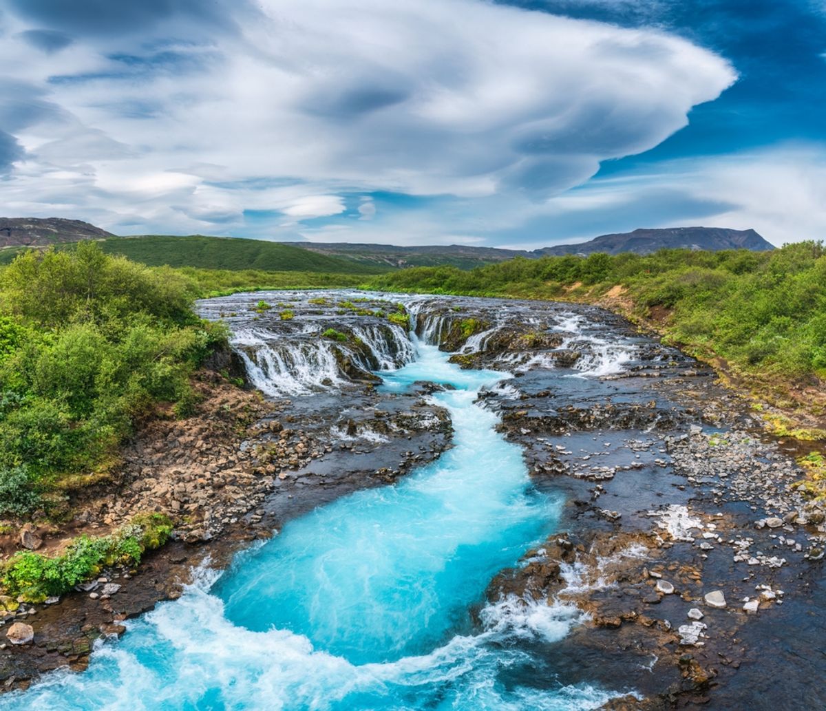 Panoramic beautiful vibrant bruarfoss waterfall flowing through rocky and wilderness in summer at Golden circle area, Iceland