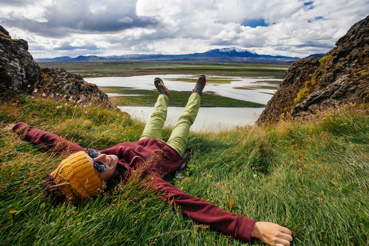Happy young woman in bright clothes traveling Iceland, enjouing nature