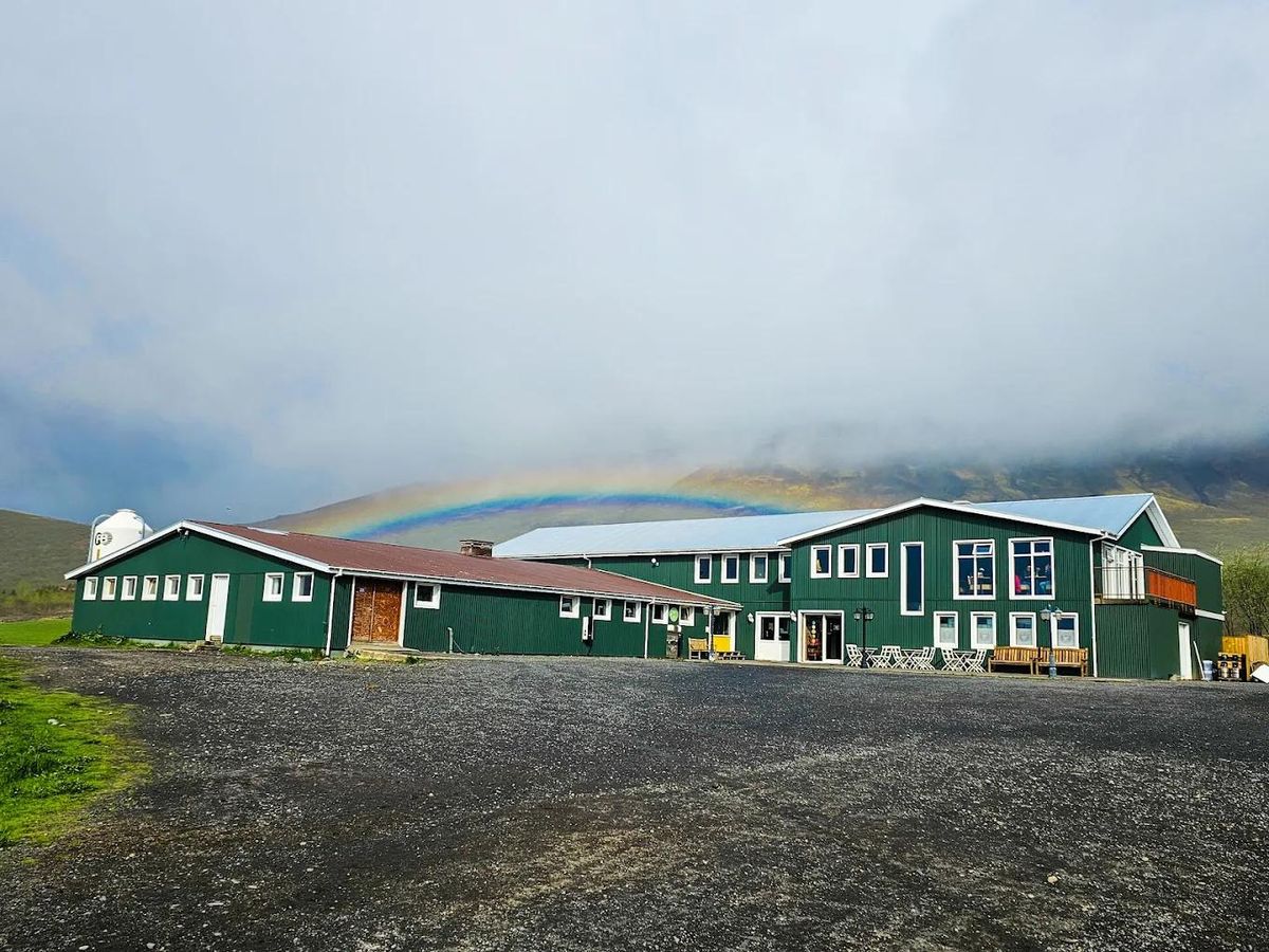 The Efstidalur farm hotel with a rainbow behind it